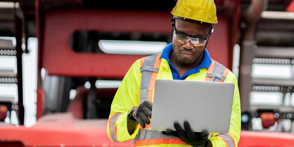 Construction Project Manager reviewing Change Order Requests on laptop